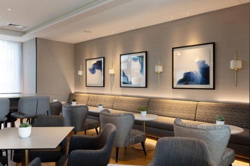 a restaurant with tables and chairs and pictures on the wall at Sheraton Nice in Nice