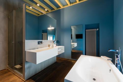 a bathroom with a white sink and a tub at Palazzo Segreti in Milan