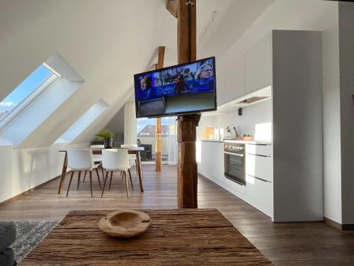 a kitchen and living room with a flat screen tv on a pole at Lunas Appartements in der alten Schule Essen in Essen