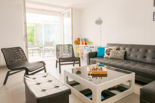 un salon avec un canapé, une table et des chaises dans l'établissement Vacances pour 6 à Saint Guénolé, à Penmarcʼh