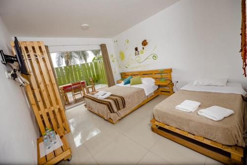 a bedroom with two beds and a balcony at Casa Boutique QX- Pachacamac in Pachacamac