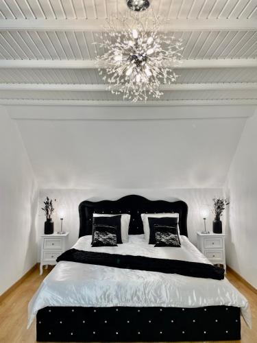 a bedroom with a large bed with a chandelier at NEW PROCHE NAUSICAA ! « Mille et Un Rêve » in Boulogne-sur-Mer