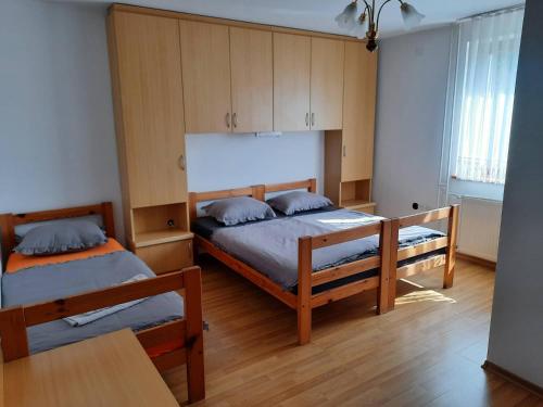 two beds in a room with wooden cabinets at Tourist Farm Lavrič in Woditz