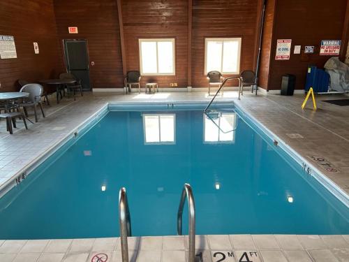 een groot zwembad met blauw water in een gebouw bij Quality Inn in North Platte