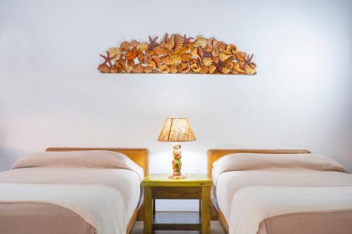 two beds in a room with a lamp on a table at Nanajuana Río Dulce in Rio Dulce