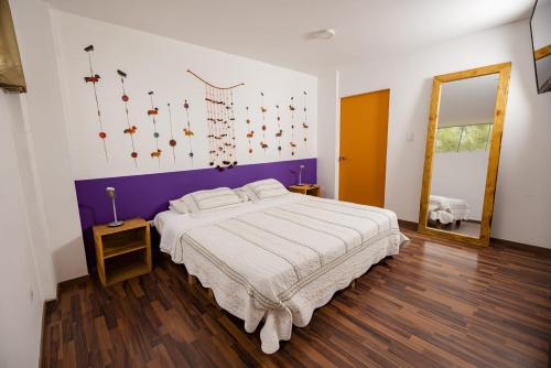 a bedroom with a large bed and a mirror at Casa Boutique QX- Pachacamac in Pachacamac