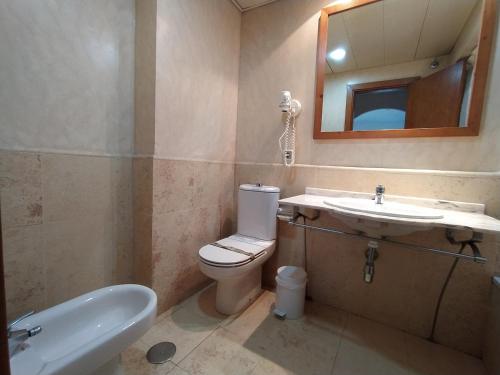 um banheiro com um vaso sanitário, uma pia e um espelho em APARTAMENTO PREMIUM UN DORMITORIO na Isla Canela