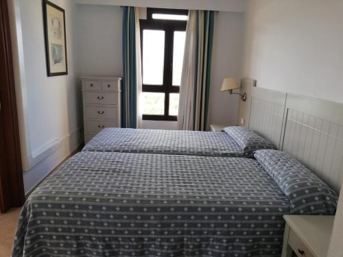 um quarto com uma cama e uma janela em APARTAMENTO PREMIUM UN DORMITORIO na Isla Canela