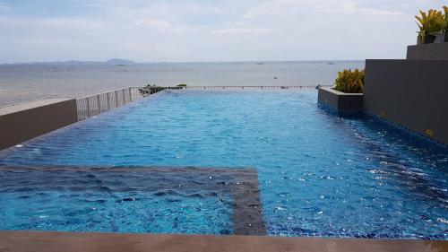 a large blue swimming pool next to the ocean at Top Flr Seaview & Rooftop Pool @Blu X in Bangsaen
