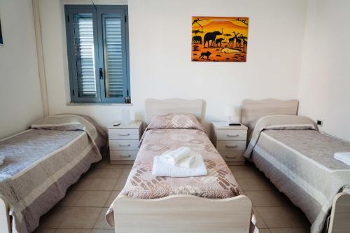 a room with three beds and a picture on the wall at Palazzo ReSilente- B&B dell'Infopoint in Castelnuovo Cilento