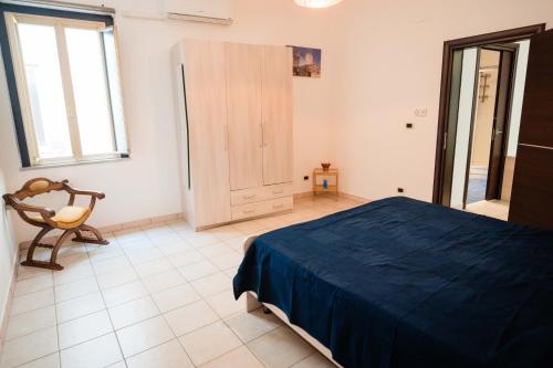 a bedroom with a bed and a chair in it at Palazzo ReSilente- B&B dell'Infopoint in Castelnuovo Cilento
