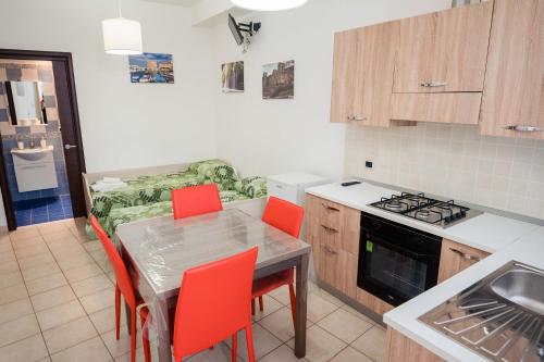 a kitchen with a table and red chairs in it at Palazzo ReSilente- B&B dell'Infopoint in Castelnuovo Cilento