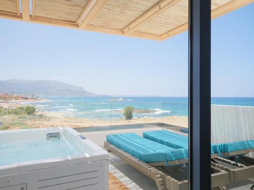 a room with a view of the ocean and a hot tub at Pyrgos Blue in Malia