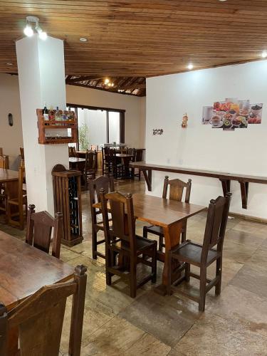 a restaurant with wooden tables and chairs in a room at Pousada Minas Goiás in Tiradentes