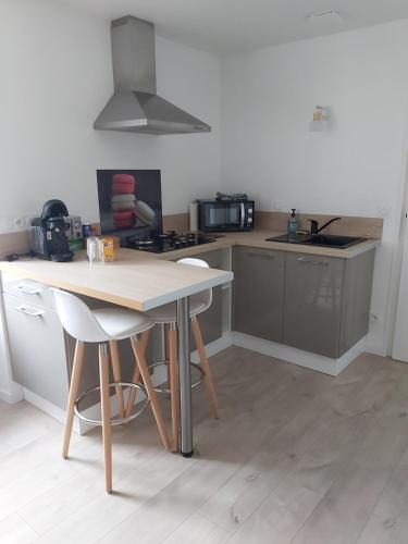 une cuisine avec une table et un comptoir dans l'établissement Studio DUNE- Côte de GRANIT ROSE, à Ploubezre