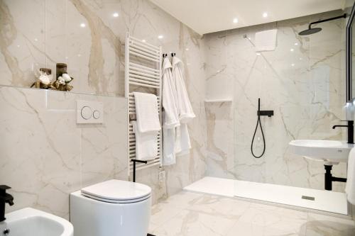 a white bathroom with a toilet and a sink at Sempione Boutique Hotel in Stresa