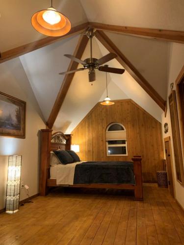 a bedroom with a bed and a ceiling fan at Ruby's Resort & RV Castle Log House in Medical Lake