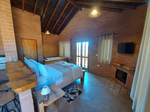 a bedroom with a large bed and a fireplace at Chalés Santa Luzia in Santo Antônio do Pinhal
