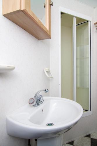 a bathroom with a white sink and a mirror at Pajūrio krantas Šventojoje in Palanga