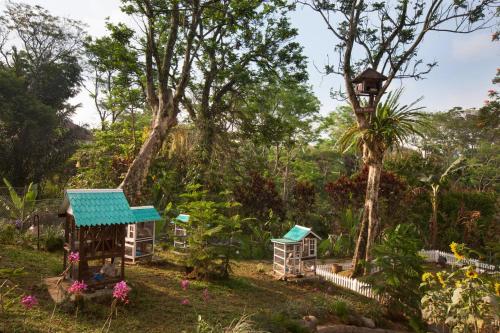 a garden with a bird house and a tree at Novus Giri Resort & Spa in Puncak