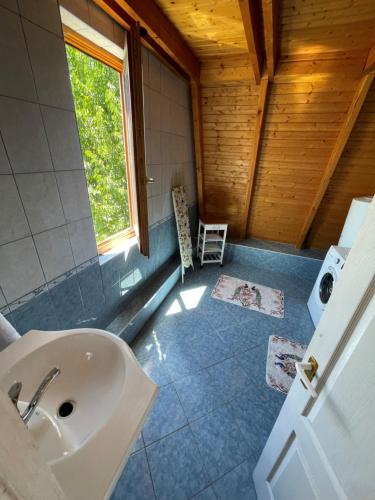 een badkamer met een wastafel en een raam bij Corner House Zsóry Spa in Mezőkövesd