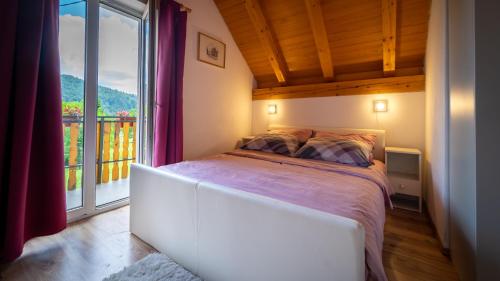 a bedroom with a bed and a large window at Holiday Home Kokot in Ravna Gora