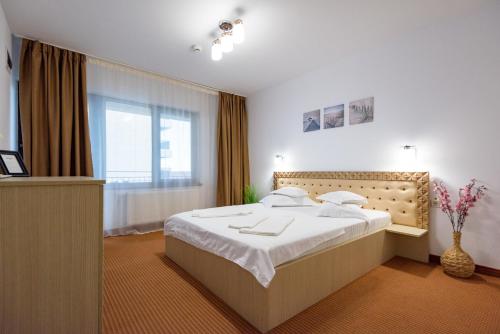 a bedroom with a large bed and a window at SaloS Beach Resort in Mamaia Sat/Năvodari