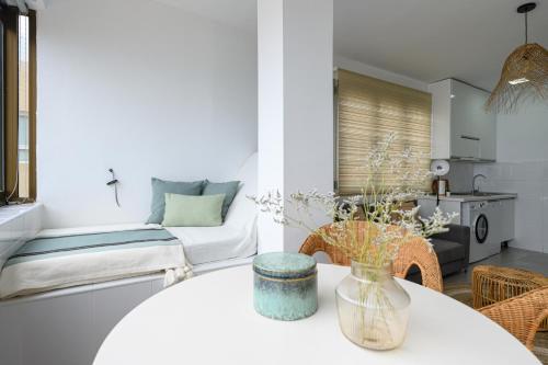 ein Wohnzimmer mit einem weißen Tisch und einer Couch in der Unterkunft Stylish Sea View Accommodation Las Canteras in Guanarteme