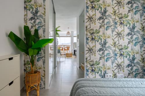 a bedroom with blue and white wallpaper with a plant at Stylish Sea View Accommodation Las Canteras in Las Palmas de Gran Canaria