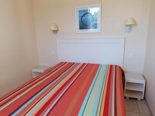 - une chambre avec un lit et une couverture rayée colorée dans l'établissement appartement 4 personnes face mer aux Sables d'Olonne, à Les Sables-dʼOlonne