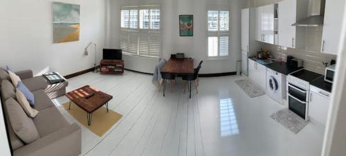 a living room with a couch and a table at Lovely Seaside Ground Floor Cottage Old Leigh in Leigh-on-Sea