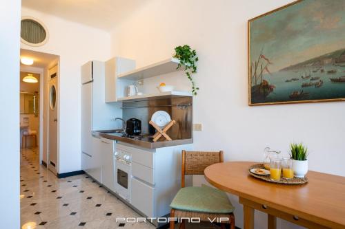 Il comprend une cuisine équipée d'une table et d'un réfrigérateur. dans l'établissement Casa San Giorgio by PortofinoVip, à Portofino