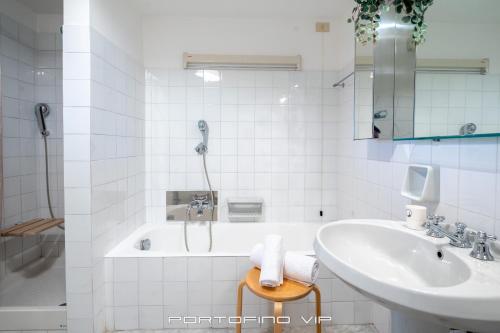 a white bathroom with a sink and a shower at San Giorgio by PortofinoVip in Portofino