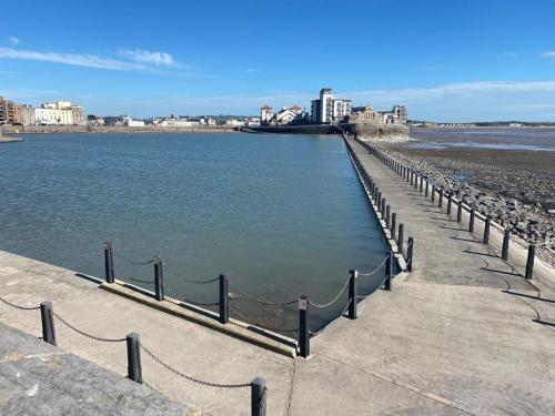 a pier on the beach next to the water at The Retreat in Weston-super-Mare