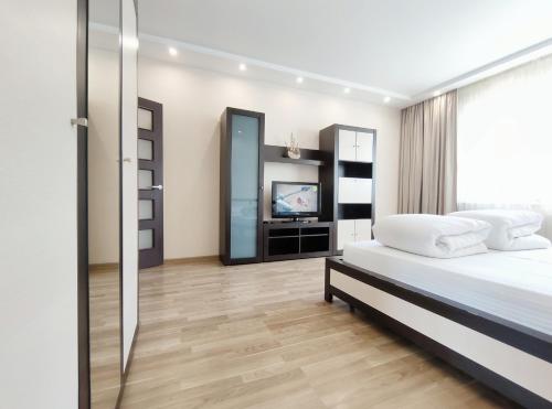 ein Schlafzimmer mit einem Bett und einem TV in der Unterkunft Positive in Lwiw