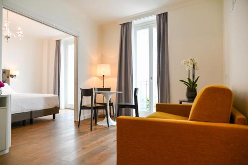 a hotel room with a bed and a table and chairs at Sempione Boutique Hotel in Stresa