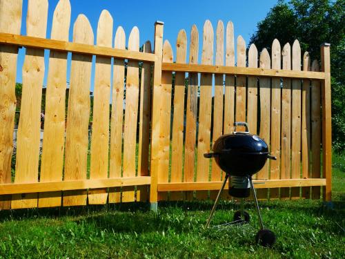 a grill sitting in front of a wooden fence at Ferienwohnung Eichkatzel in Zell