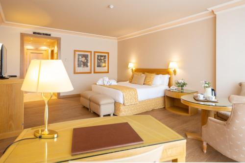 a hotel room with a bed and a table with a lamp at Gran Hotel Los Abetos in Santiago de Compostela