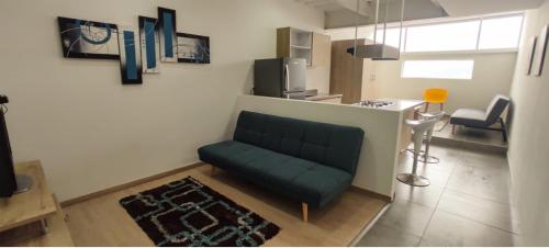 a living room with a green couch in a room at San Martin- Moderno y confortable apartaestudio sector rosales in Manizales