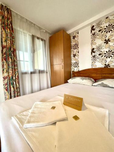 a hotel room with a bed with a sign on it at Gemini House ULTRACENTRAL 3 margarete in Costinesti