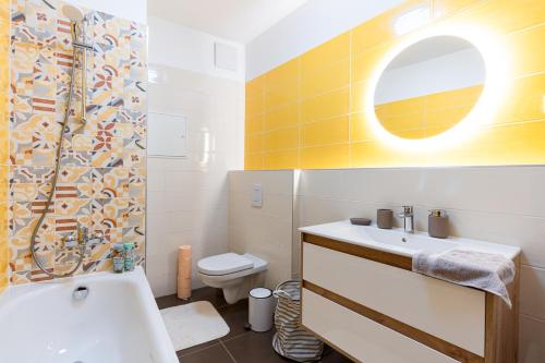 a bathroom with a sink and a toilet and a mirror at Modern & Newly built apartment with private garage in Budapest