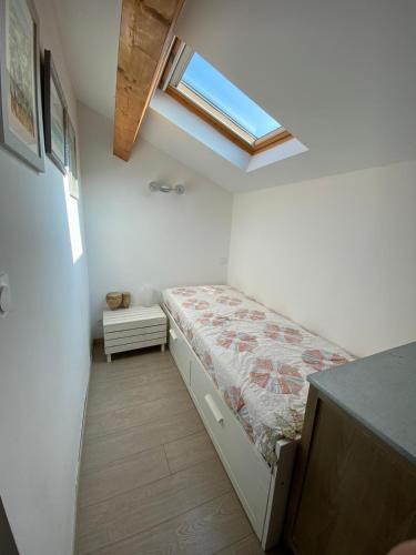 - une petite chambre avec un lit et une lucarne dans l'établissement Les Canali, à Santo-Pietro-di-Tenda