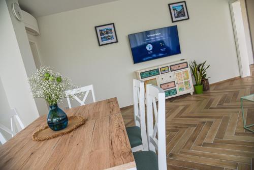 a dining room table with a vase of flowers on it at Apt - Villa Sambije with swimming pool, Dobrec - Opatija in Dobreć