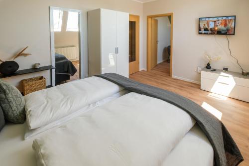 a white bed in a room with a mirror at Stadthotel Jever in Jever