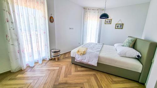 a small bedroom with a bed and a wooden floor at Apt - Villa Sambije with swimming pool, Dobrec - Opatija in Dobreć