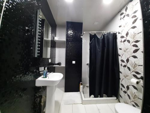 a bathroom with a black shower curtain and a sink at kessane in Akhaltsikhe
