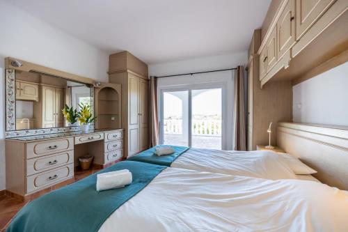 um quarto com uma cama grande e uma janela grande em Villa Mimosa em Santa Bárbara de Nexe