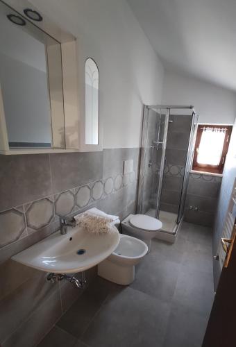 a bathroom with two sinks and a shower and a toilet at Gli Agrifogli in San Lorenzo Nuovo