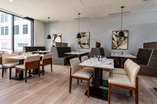 a restaurant with tables and chairs and a brick wall at Hyatt Centric Charlotte SouthPark in Charlotte