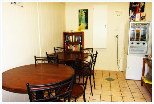 a dining room with two tables and a refrigerator at Coral Lodge Bed and Breakfast Inn in Townsville